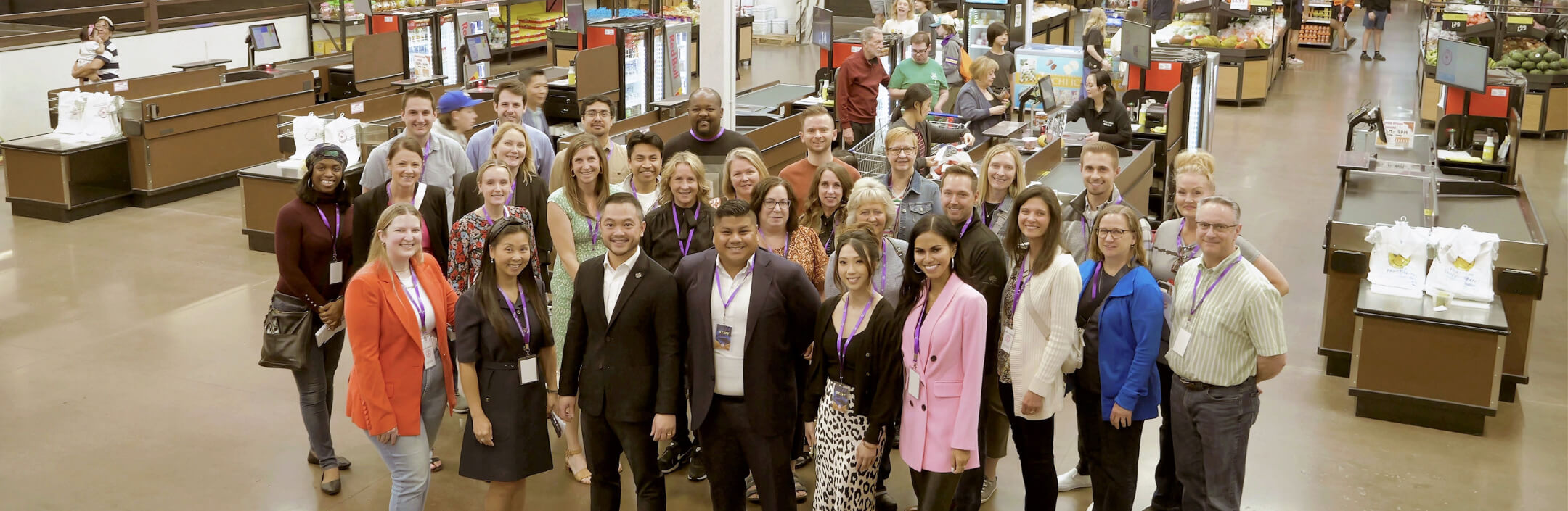 Group of people at a grocery store posing for a picture