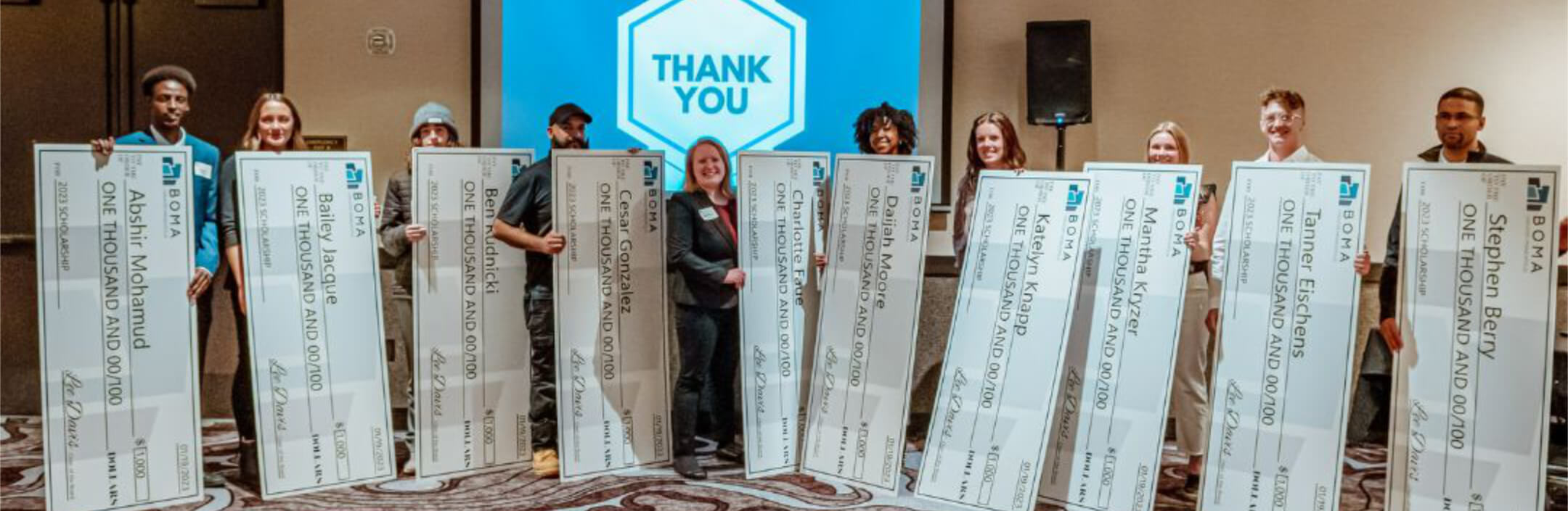 Group of people holding big checks