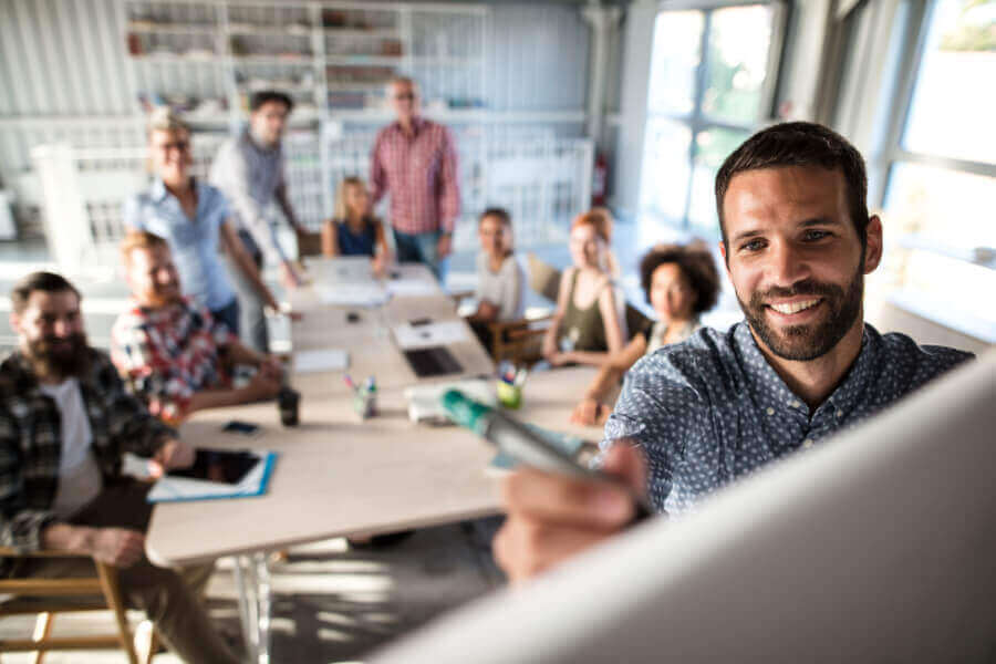 Person leading a meeting and writing on the whiteboard